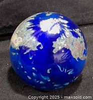 Front view of cobalt blue globe paperweight showing continents