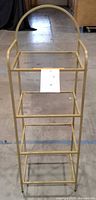 Full front view of gold-tone three-tier shelving unit