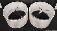 Two sealed white barrel lamp shades side by side showing overall shape and size
