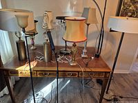 Overall view of desk with assorted lamps and floor lamps in foreground