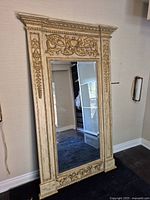 Full view of mirror showing entire carved frame and reflective surface