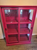 Front view of red bookcase with sliding glass doors