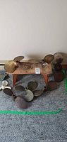 Group of nine propellers arranged on floor and small wooden stool