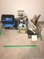 Overall lot showing charger, two boxes with gauges, speaker, wiring