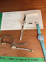 Overview of four wristwatches and Birks warranty paper