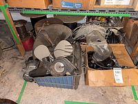 Overview of crate with fan blades, motor, wiring, adjacent box of plastic housings