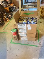 Stacked cartons with open top showing epoxy tins and separate primer can