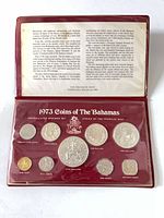 Full view of open presentation folder showing all nine coins and descriptive card