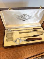 Open case showing full set of cocktail tools and glass