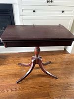 Table folded, pedestal base and legs visible