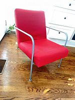 Front angle showing entire red upholstered chair with metal frame