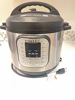 Front view of Instant Pot showing control panel and attached power cord