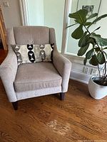 Front view of upholstered arm chair with pillow