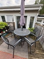 Table, four chairs, umbrella assembled on deck