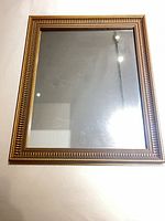 Front view of gold framed mirror showing full frame and glass