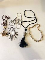All five necklaces and single earring laid out