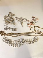 Group shot showing all eight necklaces laid out on white surface