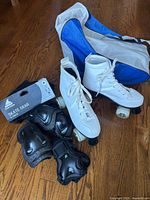 White quad skates, protective gear package and bag group view
