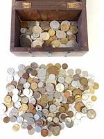 wooden chest with assorted coins inside and spread out