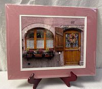 Full view of matted signed photograph on display stand