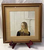 Full view of framed portrait print on stand