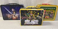Front view of all three tin lunch boxes