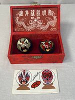 Baoding balls in red brocade box with insert displayed