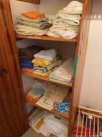 Shelves with folded towels, napkins, placemats, tablecloths and linens