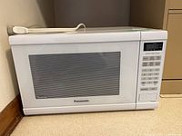 Front view of Panasonic white countertop microwave showing window and control panel