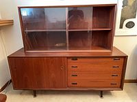 Full view showing buffet with four drawers, sliding door, and hutch with glass doors