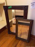 Large open frame and smaller mirror standing on floor