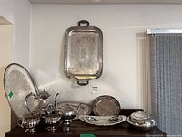 Entire set on cabinet showing all pieces including trays, pots, bowls, platter and covered dish