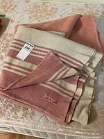 Folded wool blanket with visible Eatonia tag and striped pattern