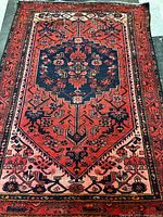 Full view of Persian wool rug showing geometric medallion pattern