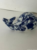 Left side profile of ceramic snail showing blue floral pattern