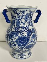 Front view of blue and white ceramic vase showing floral pattern and handles