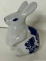 Front-left view of ceramic rabbit showing blue floral design and overall shape