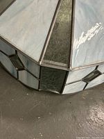 Close view of stained glass lamp shade panels showing light blue marbled glass and diamond accent