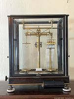 Full view of analytical balance scale in glass case