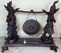 Full view of stand with figures, gong, and mallet