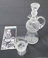 Decanter with stopper, glass, and brochure grouped