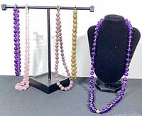 All five necklaces displayed on stand and bust