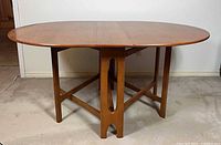 Full view of table fully open showing oval top and gateleg base