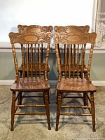 Front view of four matching oak dining chairs