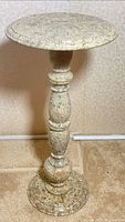 Full view of pedestal table showing circular top and turned stone column