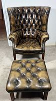 Front view of tufted leather wingback chair with ottoman