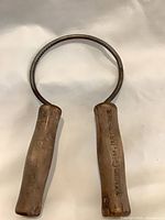 Full view of jar opener showing wood handles and metal ring