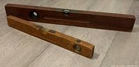 Two wooden spirit levels laid on floor showing overall form