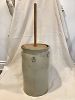Full view of stoneware butter churn with lid and dasher inserted