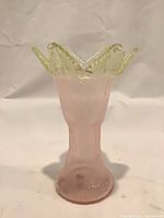 Full view of pink vase with yellow ruffled rim